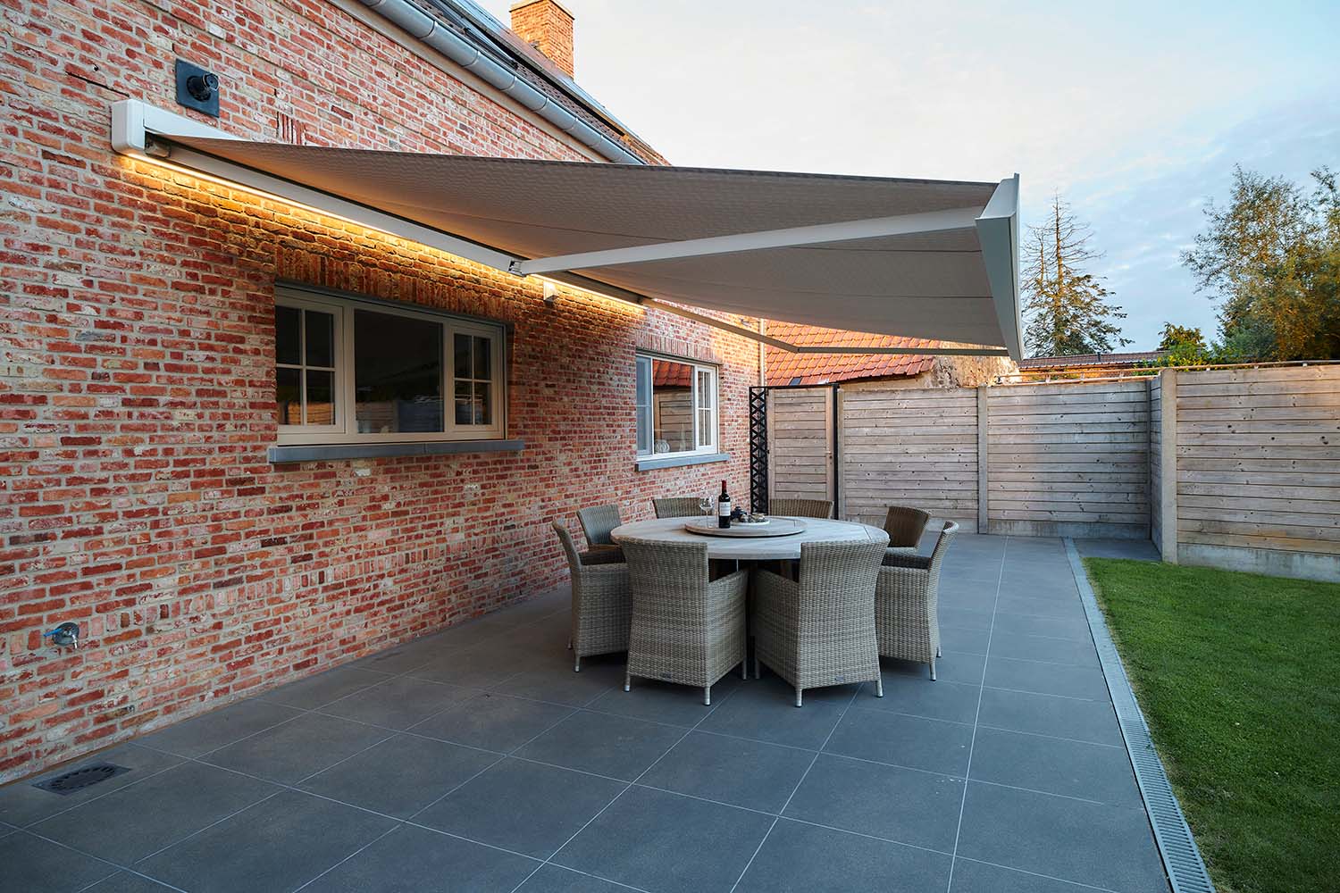 huis met lumisol luifel aan de muur dat terras beschermt tegen de zon